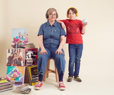 Jude Rogers photographiée avec son fils de 9 ans chez eux, une pile d'albums à côté d'eux