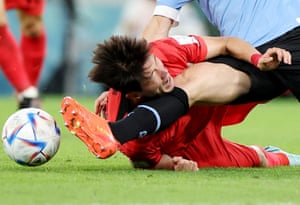 South Korea’s Hwang Ui-jo takes a shin in the chops during a challenge by Uruguay’s Diego Godín