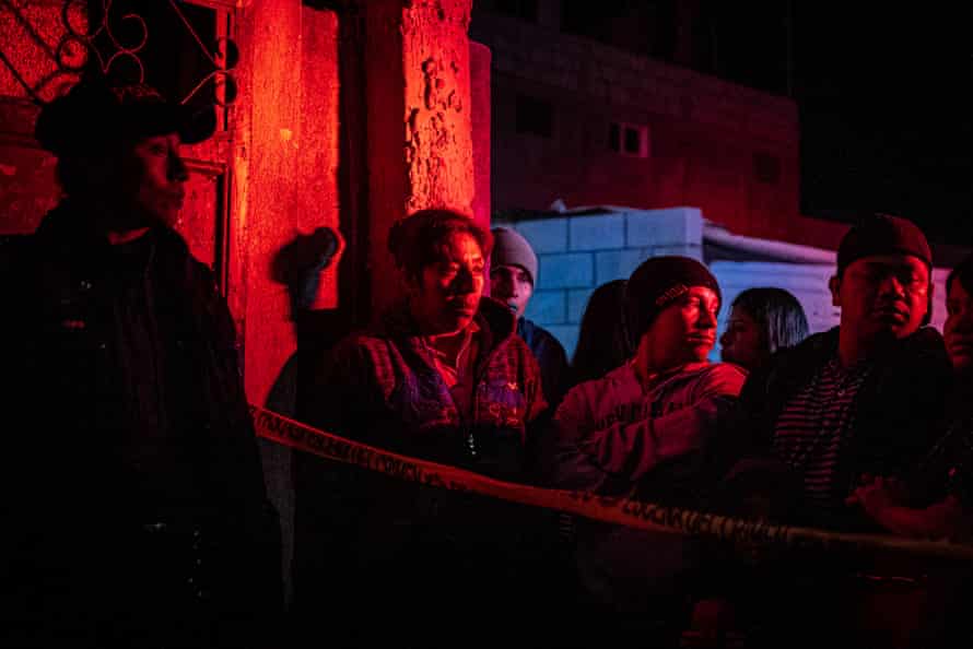 Residents of San José Pinula observe the scene of a homicide in their town
