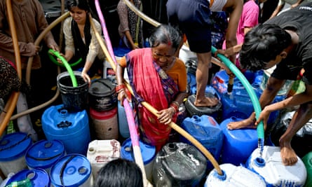Residents fill their containers with water supplied by a municipal tanker in New Delhi.
