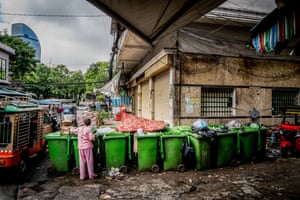 Phnom Penh, Cambodia. A recycler checks through several bins of mixed recycling