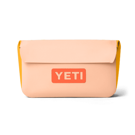 A peach rectangular bag with Yeti printed on it in orange