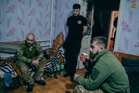 Soldiers relaxing in a wallpapered room