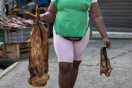 A woman carries smoked shark
