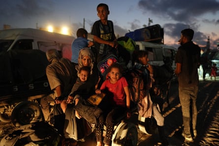 Displaced Palestinians sit on a cart as they prepare to leave Khan Younis