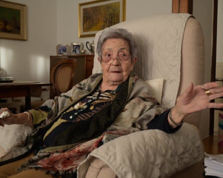 Filomena Scarpa, 100 years old, sits in an armchair and gesticulates with her left hand.