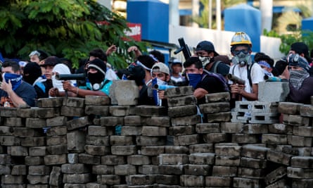 Demonstrators stand behind a barricade during a protest against President Daniel Ortega’s government in Managua on 30 May.