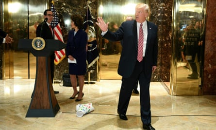 Donald Trump walks away from the podium, with his infrastructure chart left on the floor behind him along with cabinet members Gary Cohn and Elaine Chao.