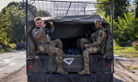 Ukrainian soldiers ride in the back of a military vehicle not far from the Ukraine-Russia border on 15 August.
