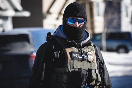 A federal agent wearing a balaclava and sunglasses