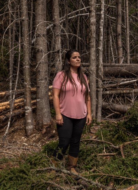Woman stands amid trees