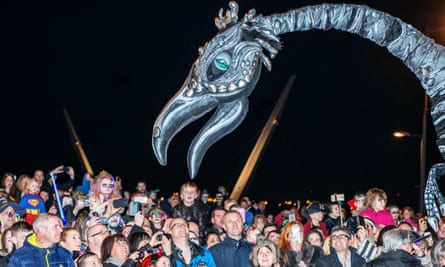 Dragon puppet above crowds at Derry Halloween Parade, Ireland.