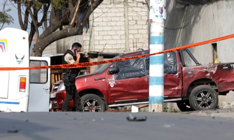 A police officer next to a car that was bombed in Guayaquil on Tuesday.
