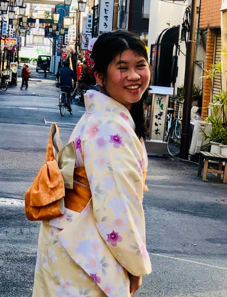 Luna on a street in Japan, wearing a colourful kimono, turning around to smile at the camera