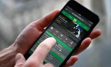 A man poses for a photograph with the online gambling website Bet365