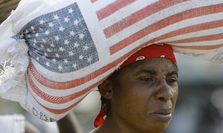 Woman carrying sack of rice with American flag on her head