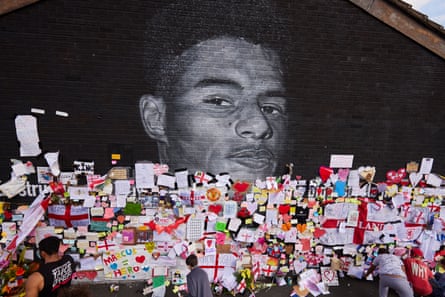 Positive messages and bouquets adorn a street mural of the England footballer Marcus Rashford in Manchester