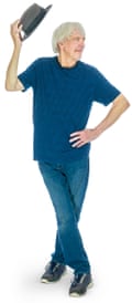 Andrew in navy T-shirt, blue jeans and trainers, standing and flourishing a hat
