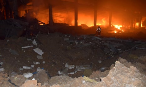 A rescuer at the scene of a warehouse hit by a Russian missile in Odesa.