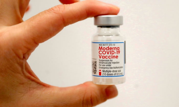 A healthcare worker holds a vial of the Moderna COVID-19 vaccine.