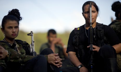 Juliana, 20, left, and Mariana, 24, rebel soldiers for the Farc’s 36th Front, listen to a commander speak on the peace negotiations with the Colombian government, in a hidden camp in Antioquia state in January 2016.