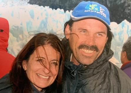 A man and a woman in hiking gear smile for a photo during a mountain trek in Patagonia. 