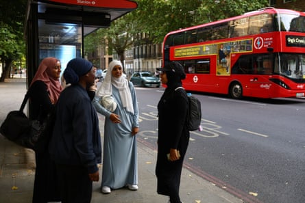 Sisterhood FC team members Atiya, 24, Kamara Davis, 30, and Amilah, 15, wait for the bus home after playing in the Ladies Super Liga tournament
