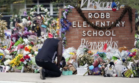 A person pays their respects at a memorial at Robb elementary school. 