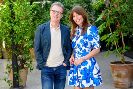 A man in a blue suit and a woman wearing a blue and white flowery dress.