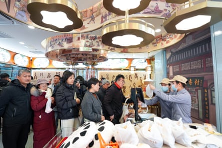Customers line up to buy snacks at a Daoxiangcun store in Beijing