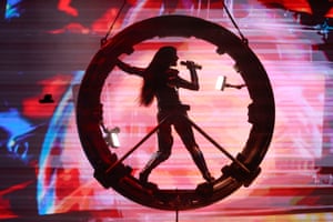 silhouette of Katy Perry singing into a microphone inside a large circular object