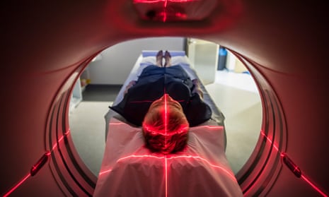 Patient lying inside a medical scanner in hospital
