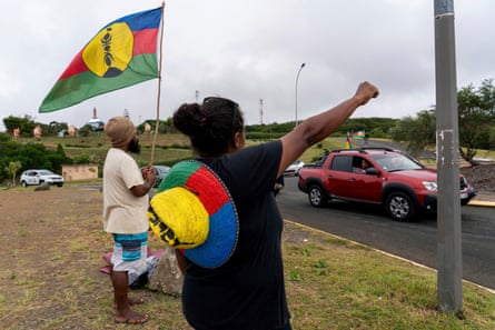 A woman waves a Kanak and Socialist National Liberation Front flag in Noumea.