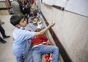 Zakariya al-Sersek checks the drip of a patient on a trolley