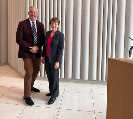 two people stand next to each other smiling