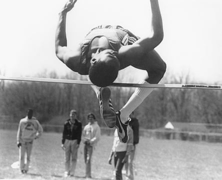 Male athlete clearing high jump bar