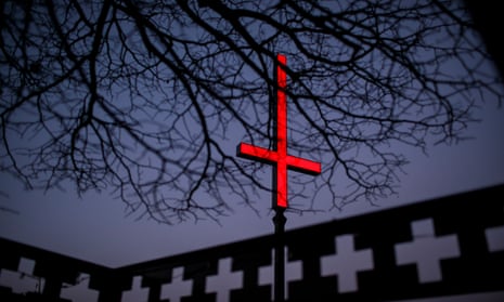 One of the neon red inverted crucifixes on Hobart’s waterfront as part of Dark Mofo.