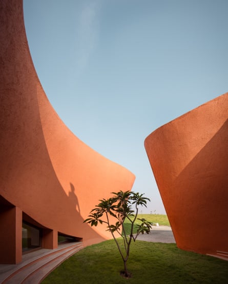 Ochre walls surround a small grassy courtyard with a plant in its centre