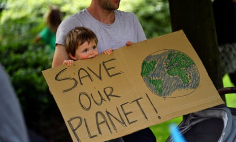 A father and his child hold up a sign as climate activists protest in London, 8 September.