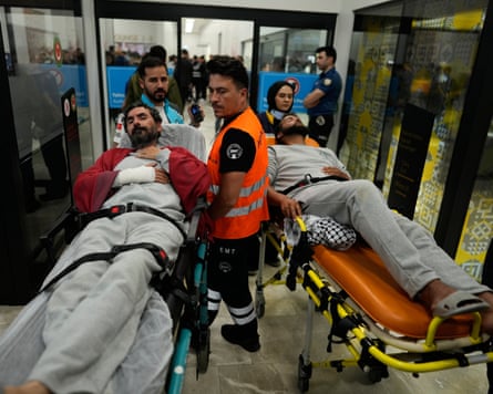 Two men on stretchers being wheeled through airport