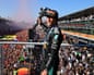 Kimi Antonelli holds a large trophy aloft on the podium above the crowds at the Italian Grand Prix.