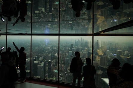 people look out windows at a hazy skyline