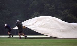 Ground staff get the covers onto the pitch at Arundel.