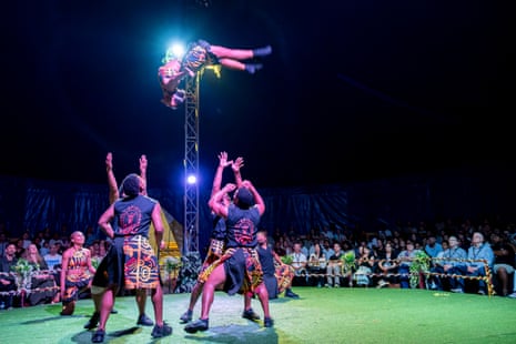 Group of performers throw another performer high into the air