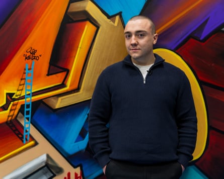 Conor Freeman standing in front of a graffiti wall.
