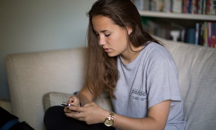 A girl sitting on a sofa using a phone