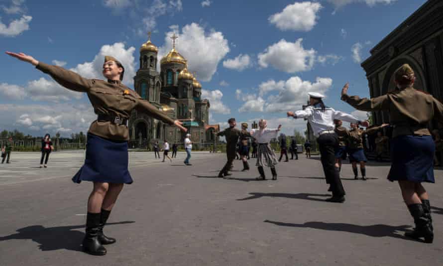 Performers dressed in Soviet era military uniforms dance in front of the cathedral.