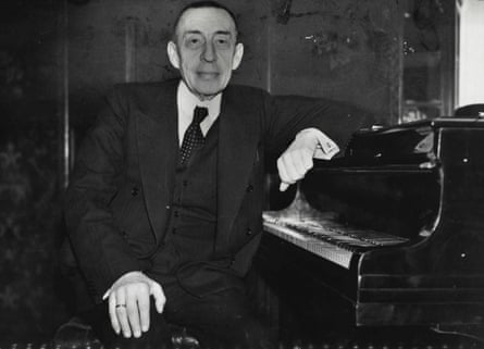 Rachmaninoff, the composer and pianist, sits at his grand piano, facing the camera in a black and white image from 1938
