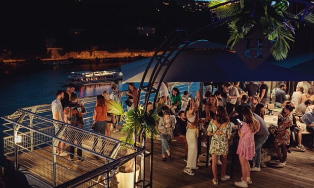 People enjoying the nightlife at the Le Sucre waterfront cultural centre, Lyon, France.