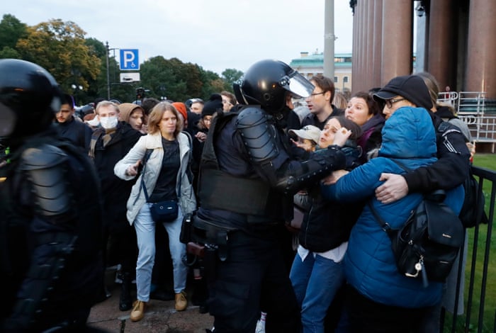 Armoured police officer grabs a protester
